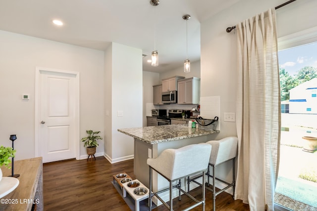 83 Plumgrass St, Bluffton, SC 29910 - kitchen featuring appliances with stainless steel finishes, a kitchen breakfast bar, gray cabinets, dark wood-type flooring, and light stone counters