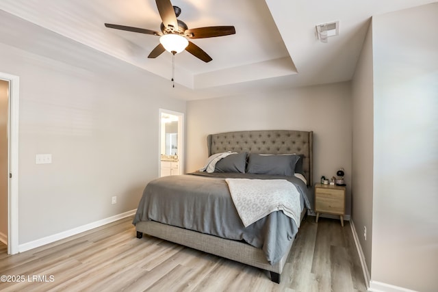 83 Plumgrass St, Bluffton, SC 29910 - bedroom featuring a tray ceiling, wood finished floors, ensuite bath, and a ceiling fan