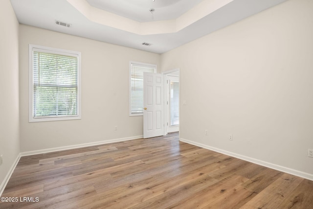 spare room featuring baseboards, visible vents, and light wood-type flooring