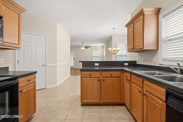kitchen with dark countertops, a sink, ceiling fan with notable chandelier, a peninsula, and black appliances