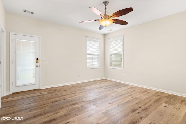 empty room with visible vents, a ceiling fan, baseboards, and light wood-type flooring
