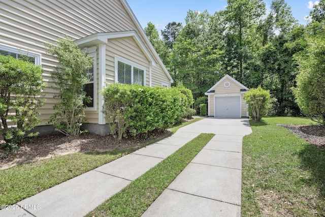 view of side of home with an outdoor structure, a garage, a lawn, and driveway