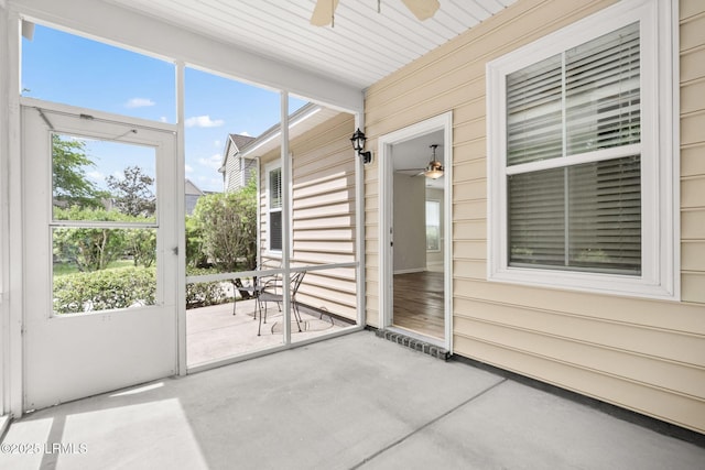 unfurnished sunroom with ceiling fan