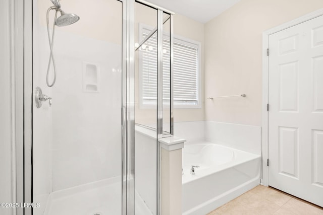 bathroom with tile patterned flooring, a shower stall, and a bath