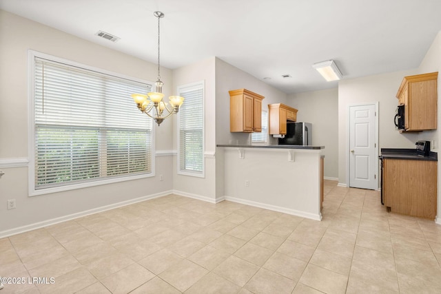 kitchen with a kitchen breakfast bar, visible vents, dark countertops, freestanding refrigerator, and an inviting chandelier