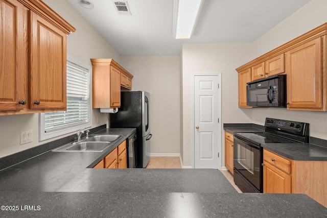 kitchen with dark countertops, a sink, baseboards, visible vents, and black appliances