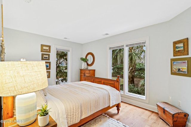 bedroom with light wood finished floors and visible vents