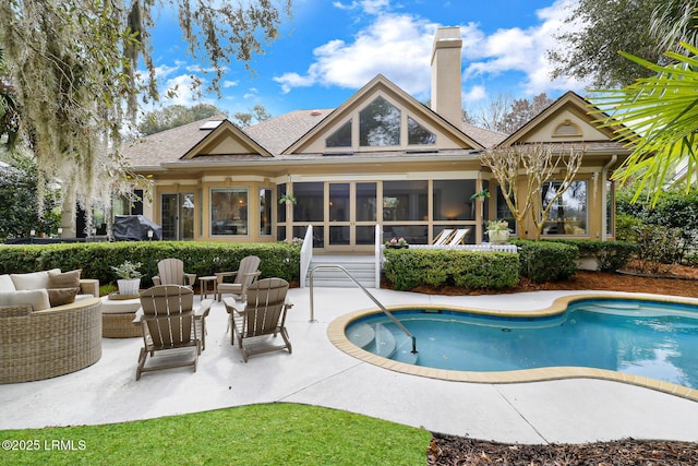 outdoor pool with a patio, outdoor lounge area, and a sunroom