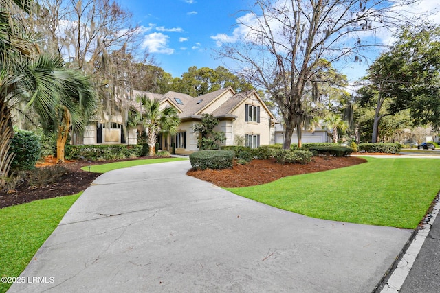 view of front of house featuring driveway, a front lawn, and stucco siding