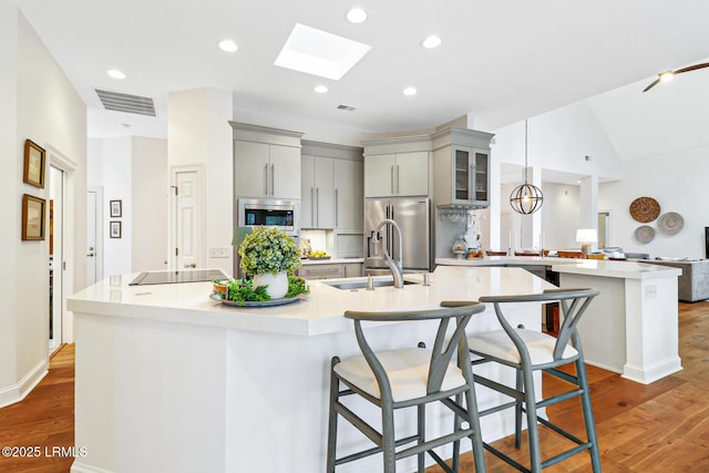 kitchen with visible vents, light countertops, appliances with stainless steel finishes, and a breakfast bar