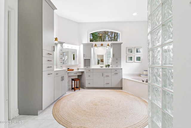 full bathroom featuring tile patterned flooring, a garden tub, and vanity