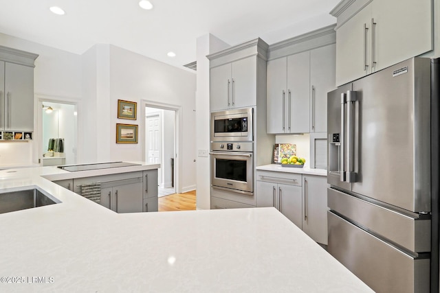 kitchen with gray cabinets, stainless steel appliances, and light countertops