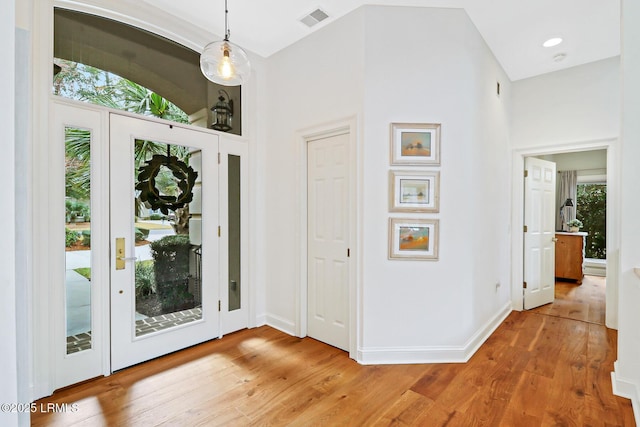 entryway featuring baseboards, visible vents, plenty of natural light, and light wood finished floors