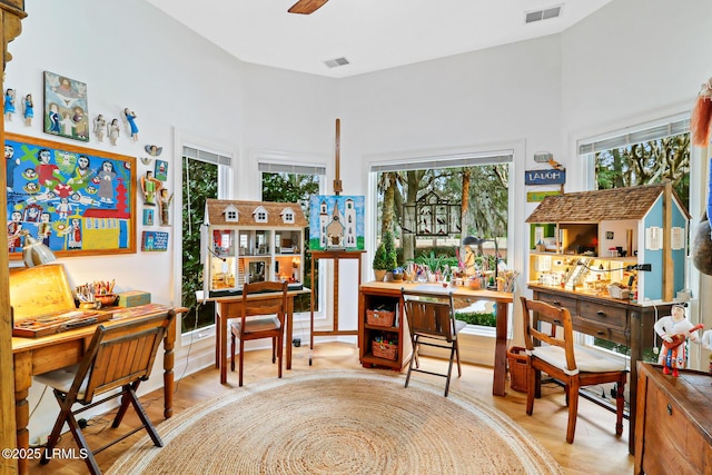 interior space featuring ceiling fan, a towering ceiling, and visible vents