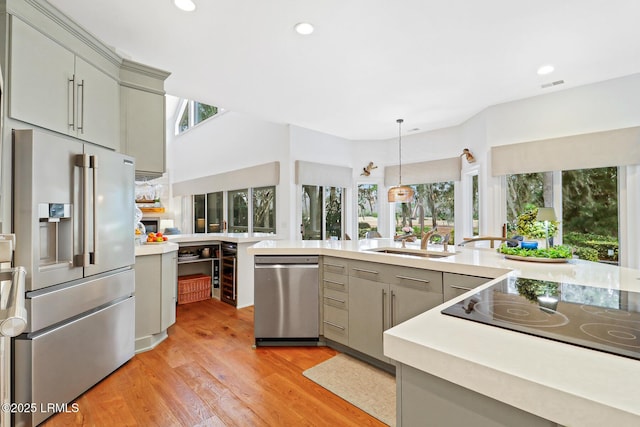 kitchen featuring appliances with stainless steel finishes, a healthy amount of sunlight, light countertops, and gray cabinetry