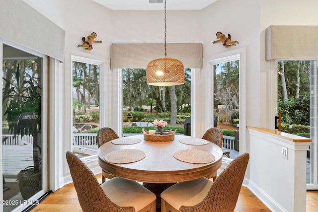 dining space with visible vents, light wood-style flooring, and baseboards