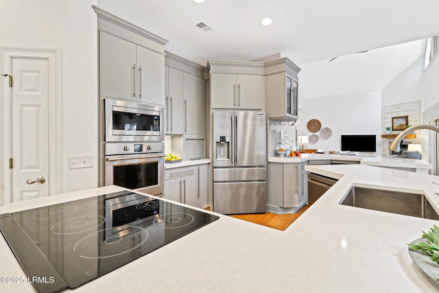 kitchen with gray cabinetry, a sink, visible vents, light countertops, and appliances with stainless steel finishes