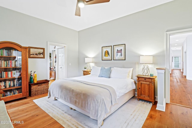 bedroom featuring a ceiling fan, connected bathroom, light wood-style flooring, and baseboards