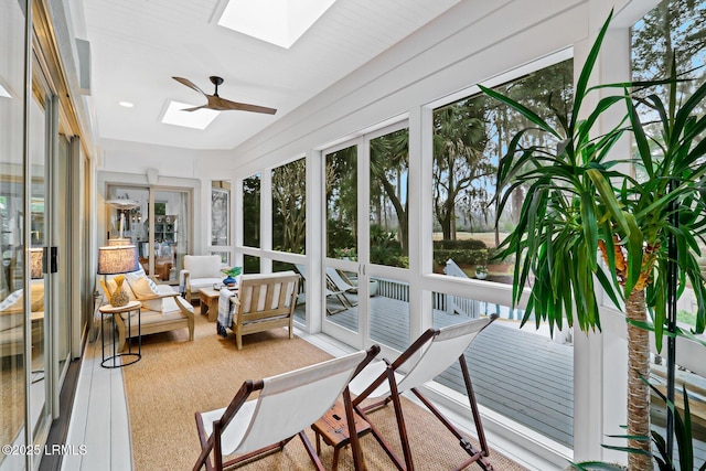 sunroom featuring a ceiling fan, a skylight, and a healthy amount of sunlight