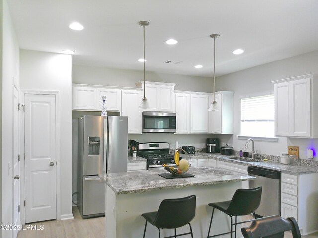 62 Keowee Ln, Beaufort, SC 29906 - kitchen featuring appliances with stainless steel finishes, white cabinetry, recessed lighting, a kitchen breakfast bar, and a kitchen island