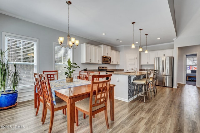 dining room with baseboards, light wood finished floors, recessed lighting, crown molding, and a chandelier