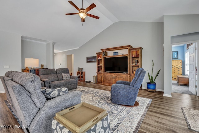 living area with baseboards, lofted ceiling, a ceiling fan, and wood finished floors