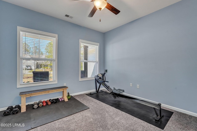 exercise area with visible vents, carpet floors, baseboards, and ceiling fan