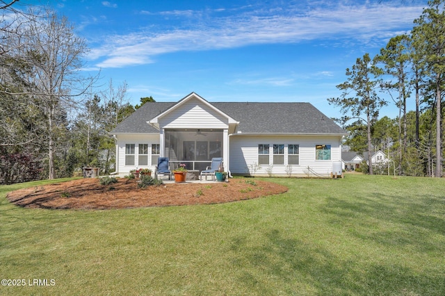 rear view of house with ceiling fan, roof with shingles, a yard, and a sunroom