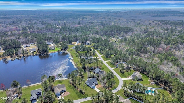 drone / aerial view featuring a water view and a wooded view