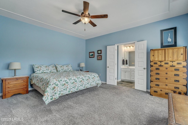 bedroom featuring ensuite bathroom, baseboards, ceiling fan, and carpet flooring