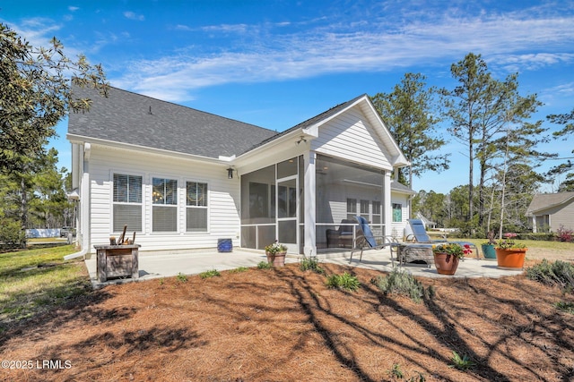 back of house with a patio area, a sunroom, and roof with shingles