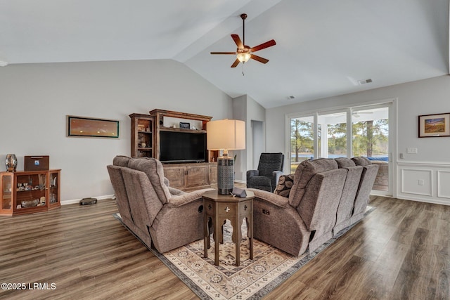 living room featuring visible vents, lofted ceiling, a ceiling fan, and wood finished floors