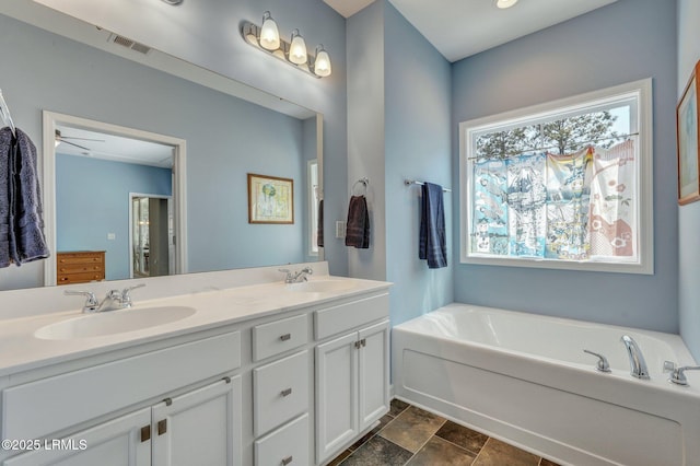 bathroom featuring a sink, visible vents, a garden tub, and double vanity