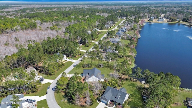 birds eye view of property featuring a forest view and a water view