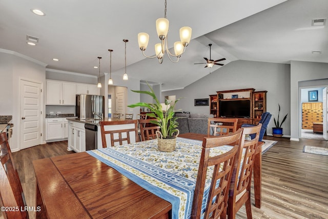 dining room with visible vents, dark wood-type flooring, ceiling fan with notable chandelier, crown molding, and vaulted ceiling