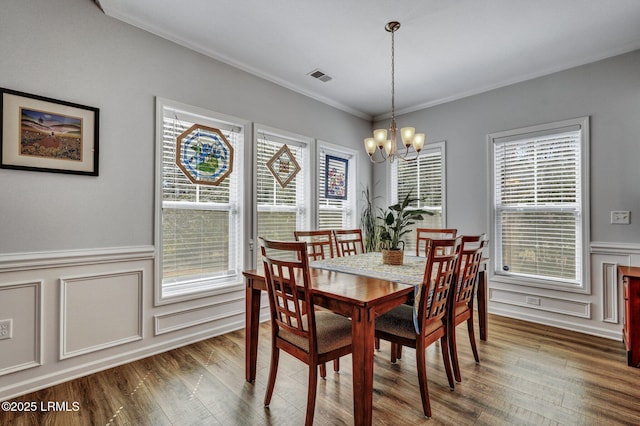 dining area featuring wood finished floors, a notable chandelier, and a healthy amount of sunlight