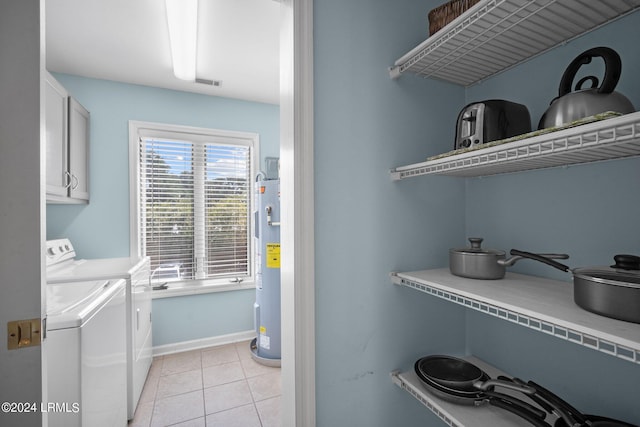 washroom featuring water heater, light tile patterned floors, cabinets, and washing machine and clothes dryer