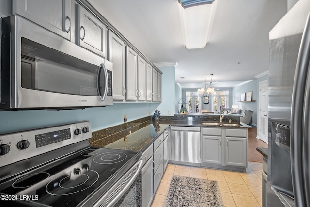 kitchen with sink, hanging light fixtures, light tile patterned floors, kitchen peninsula, and stainless steel appliances