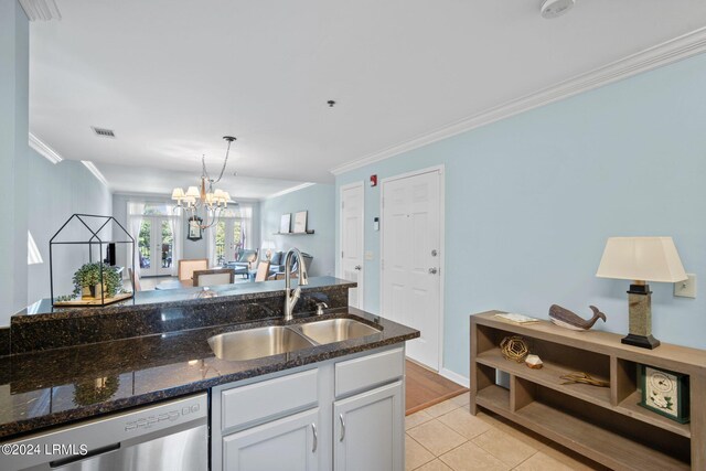 kitchen with dishwasher, sink, white cabinets, dark stone counters, and crown molding