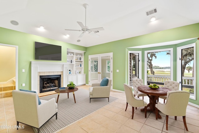 2 Doe Pt, Dataw Island, SC 29920 - living area with ceiling fan, light tile patterned floors, a tiled fireplace, built in shelves, and french doors