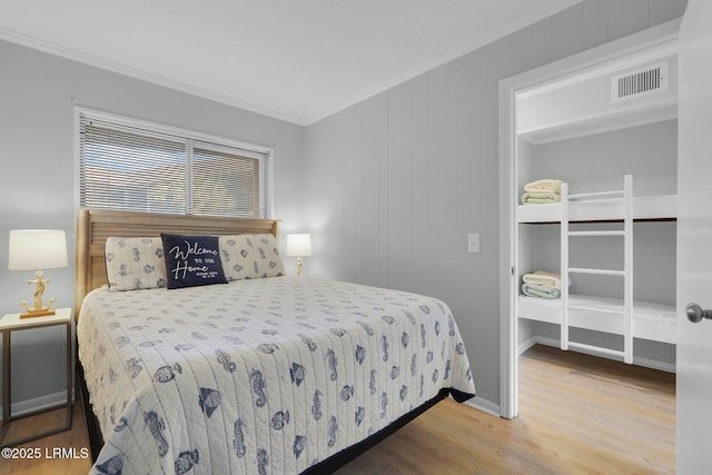 bedroom with wood-type flooring and ornamental molding