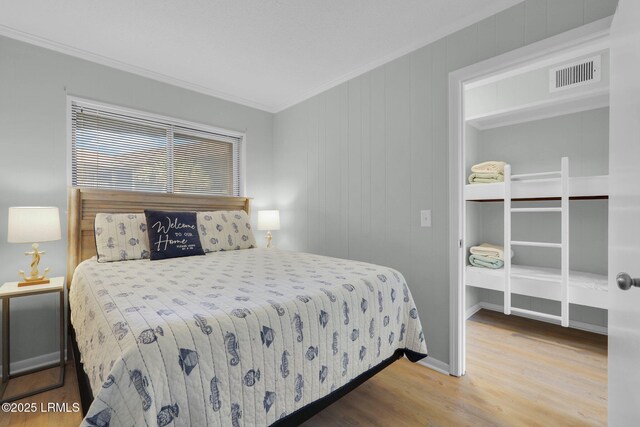 bedroom with wood-type flooring and ornamental molding