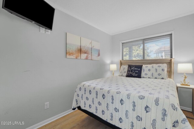 bedroom featuring ornamental molding and hardwood / wood-style floors