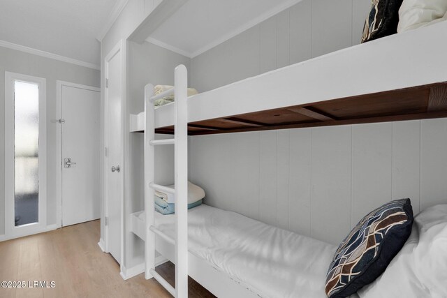 bedroom featuring ornamental molding and light hardwood / wood-style flooring