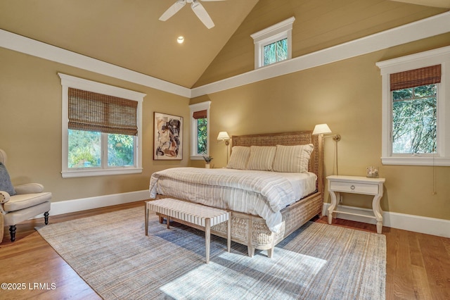 bedroom with ceiling fan, high vaulted ceiling, and light hardwood / wood-style flooring