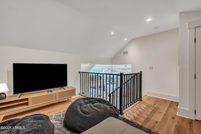 living room featuring lofted ceiling and light wood-type flooring