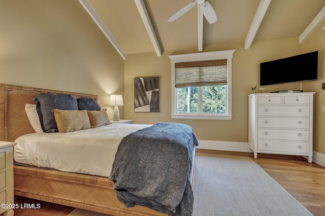 bedroom featuring lofted ceiling with beams, light hardwood / wood-style floors, and ceiling fan