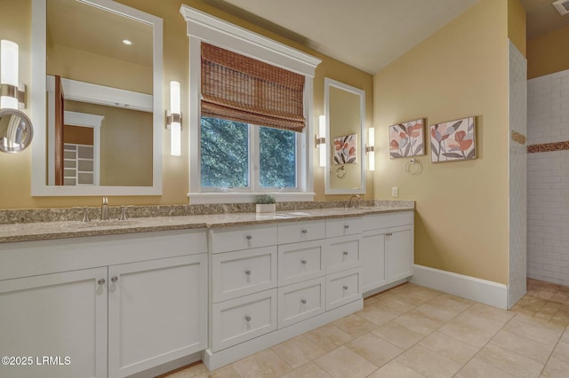 bathroom with vanity, tiled shower, and tile patterned floors