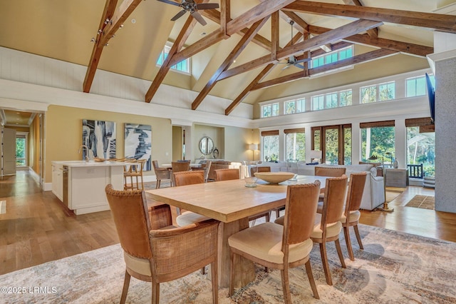 dining area featuring beamed ceiling, ceiling fan, high vaulted ceiling, and light hardwood / wood-style floors