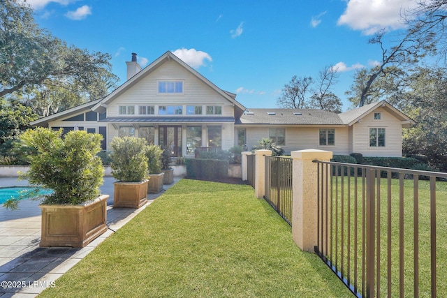 back of property featuring a yard and a sunroom